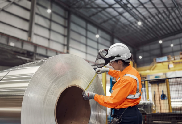 BlueScope employee measuring a roll of steel in a manufacturing facility